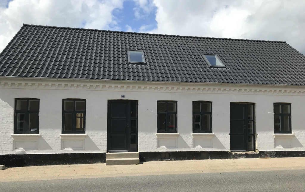 Totalrenoveret dobbelthus med sort tag og sprossevinduer