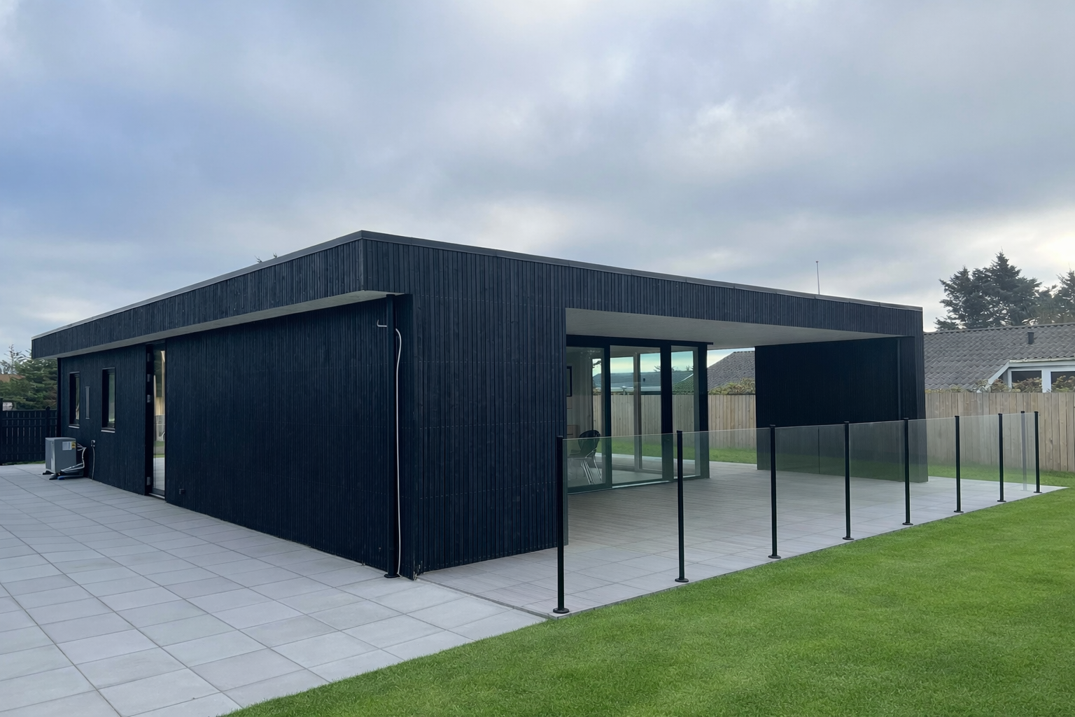 Sommerhus med fladt tag og sort træbeklædning