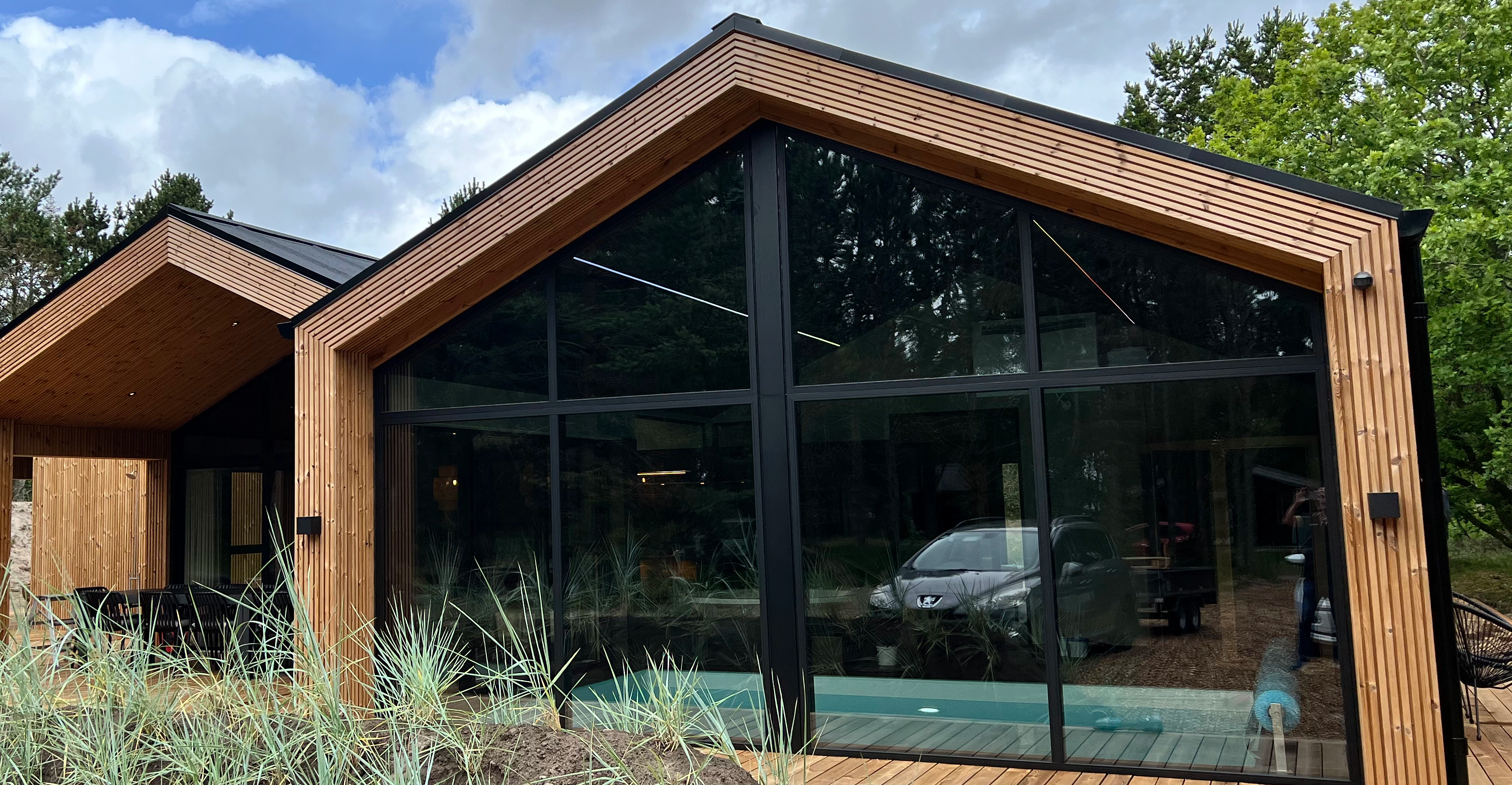 Sort arkitekttegnet sommerhus med store vinduer og godt lysindfald